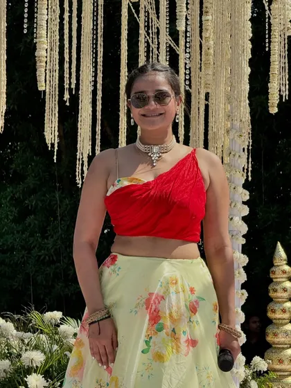 A vibrant floral lehenga for a daytime wedding event. Standing here against the beautiful decor, I felt perfectly in tune with the celebration's atmosphere.
