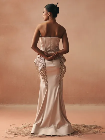 A view of the Zikaron gown from the back, showcasing the clean lines of the corseted form and the elegant flare of the fish-cut skirt, highlighted with handcrafted paisley embroidery.