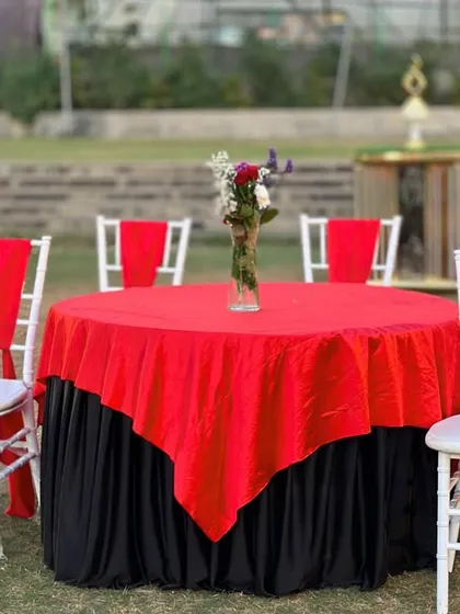 A close-up of a VIP table at a reception, with a red and black theme that is both bold and elegant.