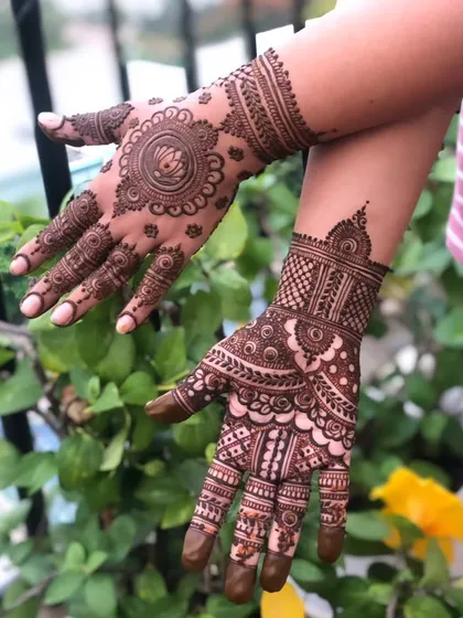 A beautiful mix of styles, with a lotus mandala on the back of one hand and a full intricate pattern on the other.