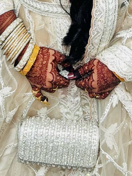 A beautiful moment captured, showing the rich henna stain as the bride holds her purse. It’s these little details that make the wedding look complete.