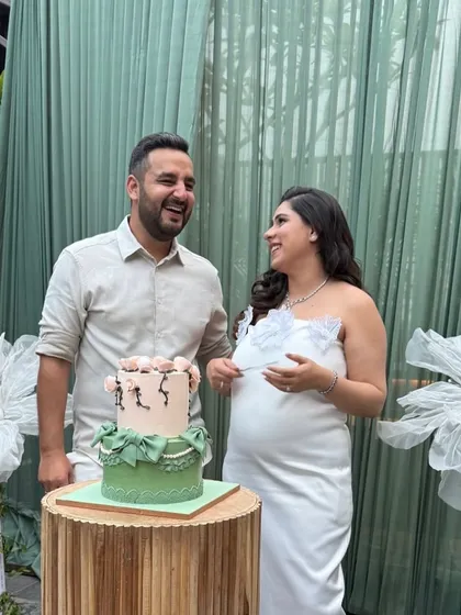 Capturing pure joy at a baby shower we decorated. We created an elegant backdrop with sage green drapes and delicate, handmade white flowers, providing the perfect setting for the parents-to-be.