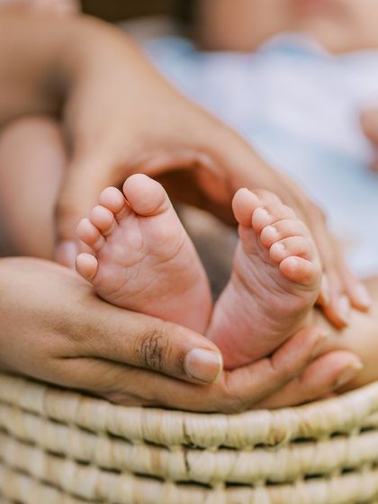 A close-up on the baby's feet being held in a parent's hands, a classic and timeless detail shot from a newborn session.