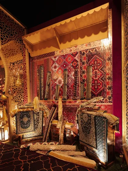 Another angle of the rug stall, showing how the layers of textiles and warm lighting created a cozy and inviting corner within the larger event space.