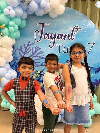 Showing off their cool, temporary sea-creature tattoos that were part of the "Under The Sea" party fun. We love adding little extras to make the theme come alive.