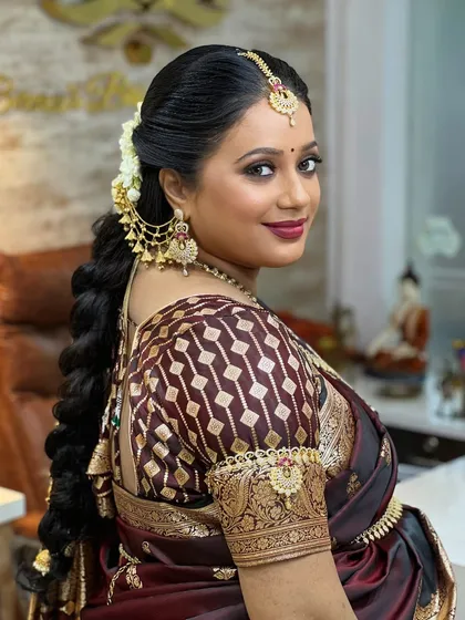 A side profile showing her beautiful braided hairstyle, adorned with traditional hair accessories that are also available for rent.
