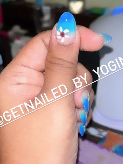 This is a beautiful blue ombré set I did on my own acrylic extensions. I added a small, hand-painted white flower for a delicate and pretty touch.