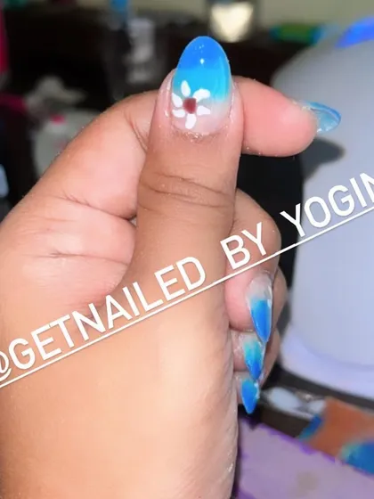 This is a beautiful blue ombré set I did on my own acrylic extensions. I added a small, hand-painted white flower for a delicate and pretty touch.
