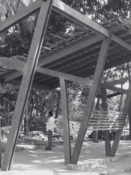 A reflective moment during the construction of K-Lagoon. The angular timber frame structure stands in dialogue with the organic forms of the surrounding trees, a synthesis of the man-made and the natural.
