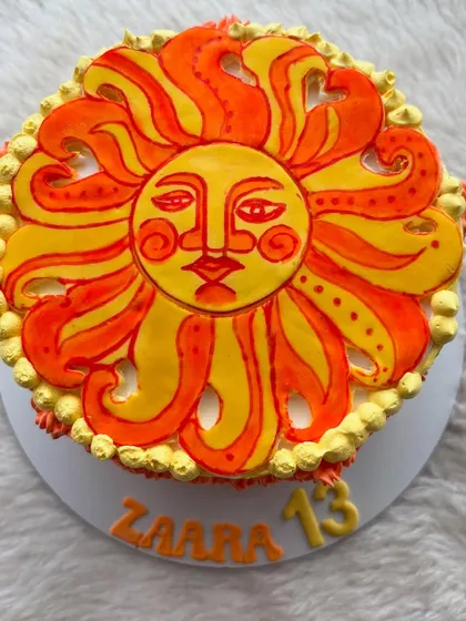 A hand-painted sun cake for a 13th birthday. The bright orange and yellow design is so cheerful.