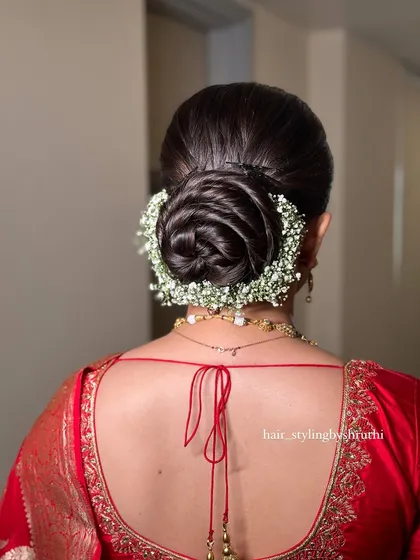 This is a detailed look at a floral rose bun, crafted with precision and encircled by delicate baby's breath. It's a popular and elegant choice for brides and is suitable for receptions and other formal events.