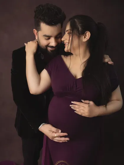 A sweet and candid-style couple's portrait. The couple shares a look of love and excitement, capturing the genuine emotion of their pregnancy journey.