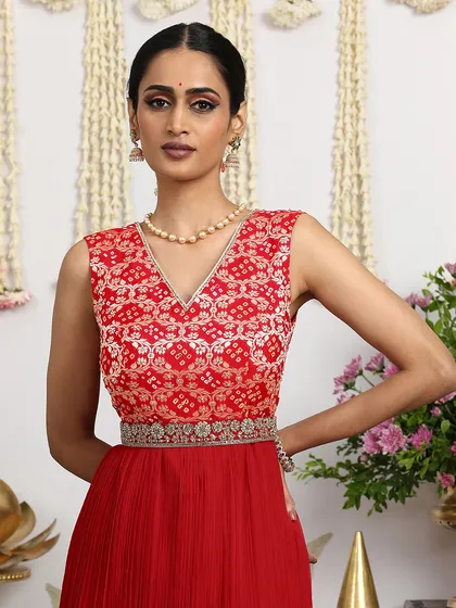 A close-up of the red Bandhani dress, showcasing the intricate tie-dye pattern and the delicate embroidery on the yoke.