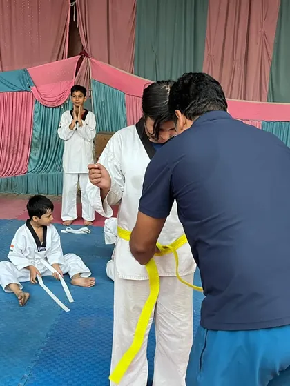 The moment of promotion is a special one. This photo captures a student receiving her new belt after a successful test.