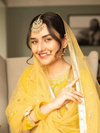 Inspired by the royal aesthetics of Heeramandi, this look from a creative shoot features a dewy base, bold brows, and a subtle nude lip. The intricate nath and passa complete this regal and artistic expression of beauty.