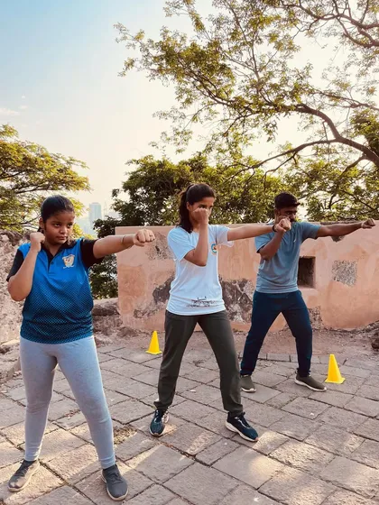 This is where we forge warriors. Our outdoor training sessions, like this one at a historic fort, are designed to build resilience and adaptability. Here, students practice their kickboxing stance and punches, learning to focus amidst the elements.