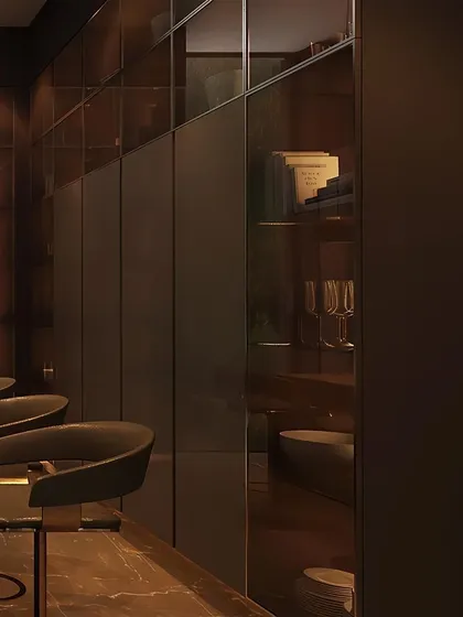 This view shows a sleek, dark-themed bar area with integrated, smoked-glass cabinetry. The design provides extensive storage while maintaining a moody, sophisticated aesthetic, with rows of bar stools ready for guests.