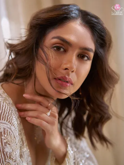 A close-up of Mrunal Thakur from the HT City Showstoppers shoot. The soft makeup and windswept hair complement the delicate embellishments of the jacket, creating a look of effortless beauty.