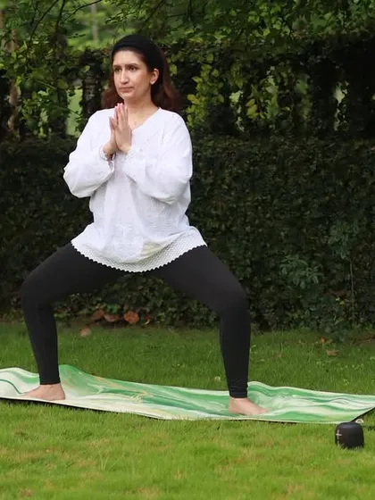Demonstrating the Goddess Pose, or Utkata Konasana, during an outdoor class. This is a powerful stance that builds strength in the legs and opens the hips.