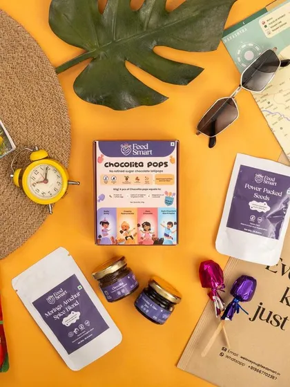 A travel-themed flat lay for Feedsmart's snacks, styled with a map and sunglasses. This concept positions the products as convenient, on-the-go options for families.