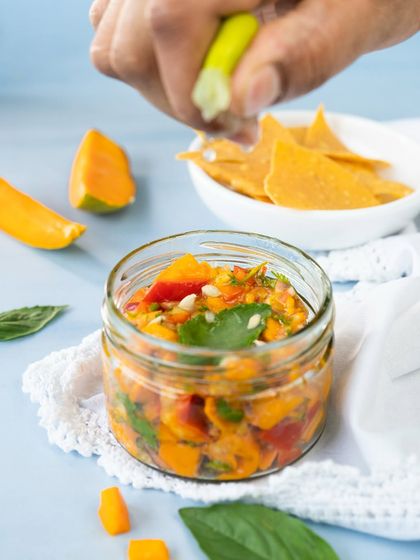 A close-up of the fresh mango salsa, showing the chunks of ripe mango and a squeeze of lime.