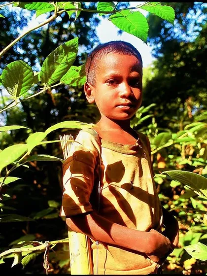 A tribal boy in Mumbai's SGNP, sometime around 1985. He held a dead babbler, hunted with a simple arrow. He knew the living forest well, a sight you are unlikely to see today.