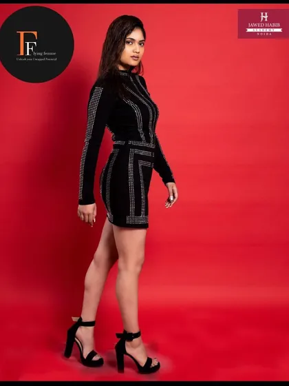 A full length view of the model in the black dress, highlighting the sleek and stylish silhouette.