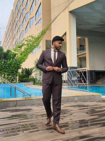 This cocoa-colored suit is a versatile choice for any formal occasion or wedding. Pictured here by the poolside, it shows how a well-tailored suit can look stylish and effortless in any setting.