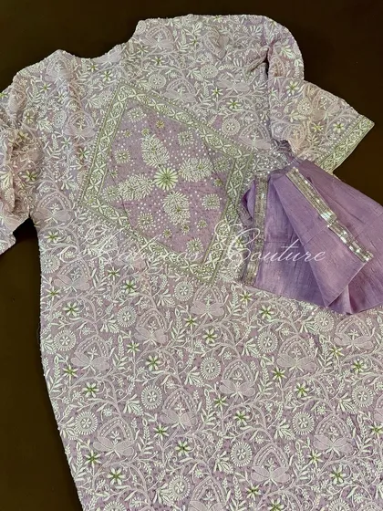 A view of the back of the lilac Anarkali, highlighting the detailed embroidery that continues across the entire garment.