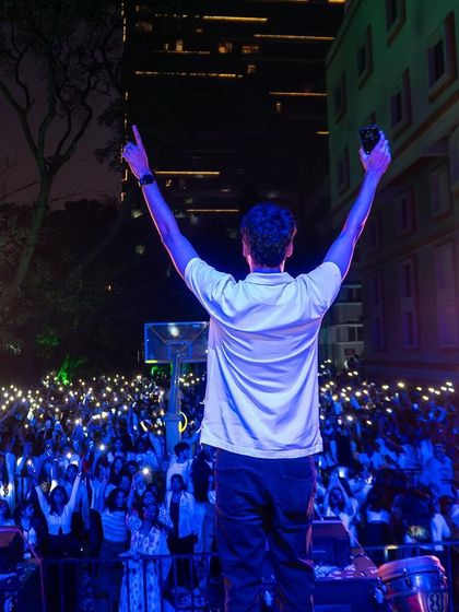 Arms up, facing the crowd at MCC's White Summerland. The energy exchange between me and the audience is what fuels the performance.