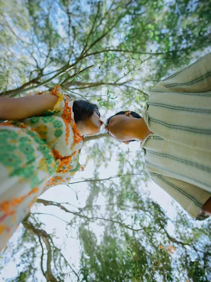 A unique low-angle shot looking up at the couple through the trees. This artistic perspective adds a creative and memorable touch to their pre-wedding album.