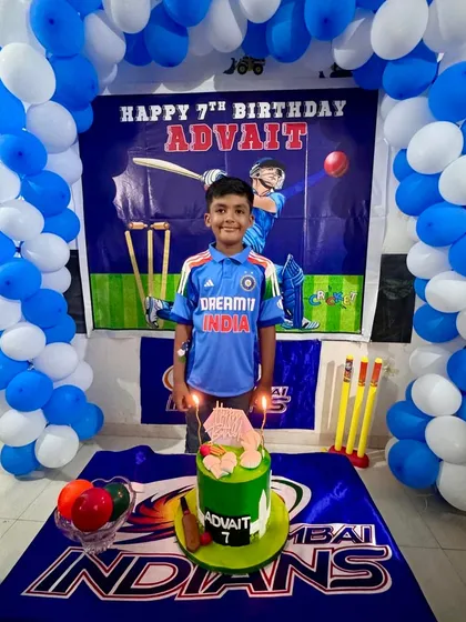 A happy young cricketer celebrating his 7th birthday with the custom cake I made to match his party's theme.