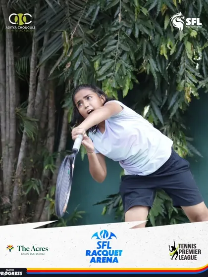 A young female player puts all her effort into a powerful two-handed backhand. The intensity on her face reflects the high stakes of tournament play.
