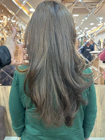 A client showing off her new ash brown global hair color. This single-process color provides a uniform, sophisticated look with a healthy shine.