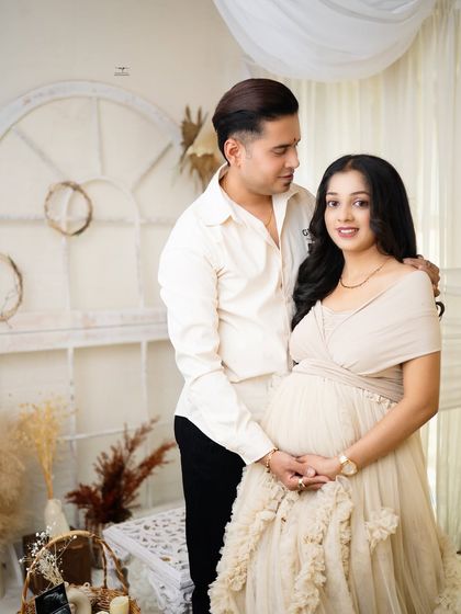 A classic and beautiful portrait of the couple, smiling at the camera. Their coordinated neutral outfits blend perfectly with the serene, boho-inspired decor.