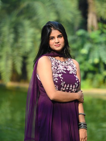 A classic portrait in the same outdoor setting, showcasing the intricate embroidery on her dress.