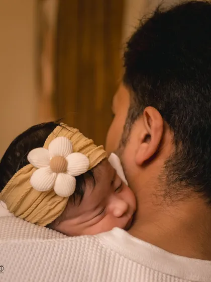 A tender moment between a father and his newborn daughter. Capturing this secure and loving embrace is a key part of documenting the story of a new family.