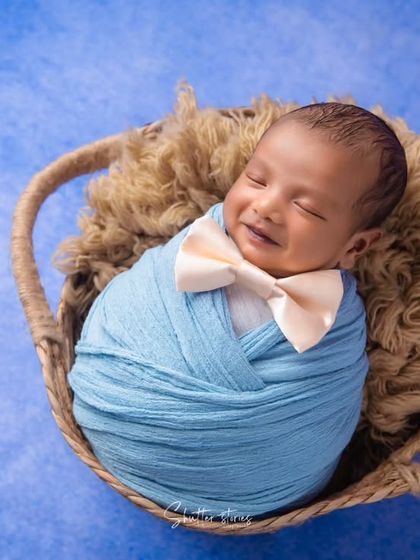 Another angle capturing the newborn's sleepy smile, a truly precious and heartwarming moment.