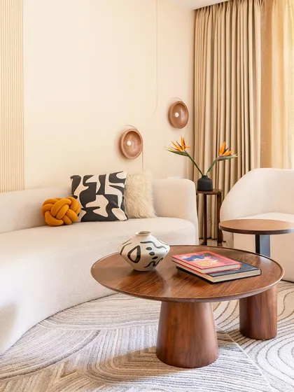 A closer view of the custom coffee table and curved sofa, showcasing the interplay of organic shapes and natural materials that define this home's Wabi-Sabi style.