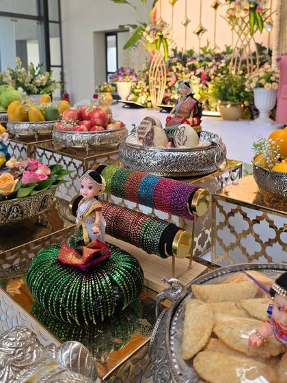 A beautiful arrangement for a bangle ceremony, with dolls, colorful bangles, and offerings of fruits and sweets.