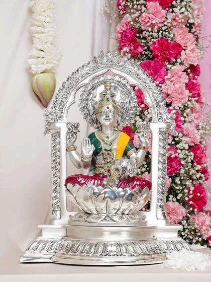 The Goddess of wealth and prosperity, Lakshmi, is captured in stunning detail in this silver-plated idol. Seated within a regal arch, she brings an aura of grace and abundance to your home.