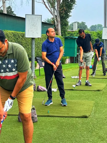 A line of focused golfers, each working on their individual swing mechanics on a beautiful day.