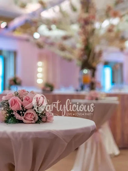 A close-up of a simple, elegant cocktail table with a small bouquet of pink roses, showing that even the smallest details are thoughtfully styled.