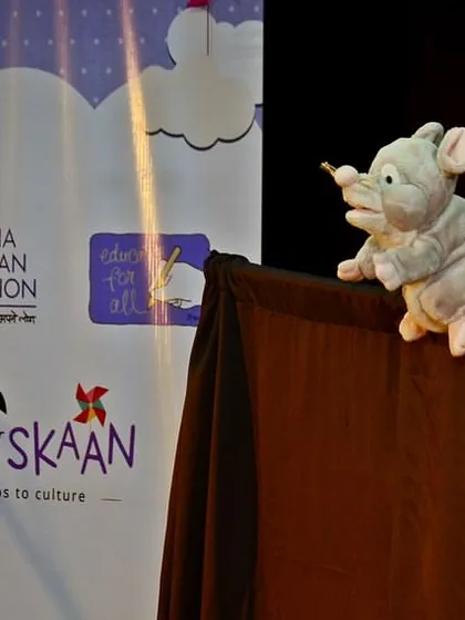 A tiny mouse puppet peeking over the stage. This little hero is from the classic fable "The Lion and the Mouse," a story that teaches us that even the smallest among us can be a great friend.