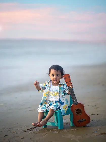 A little musician on the shore. We love incorporating simple props like this small guitar into our beach shoots to add a touch of personality and fun.