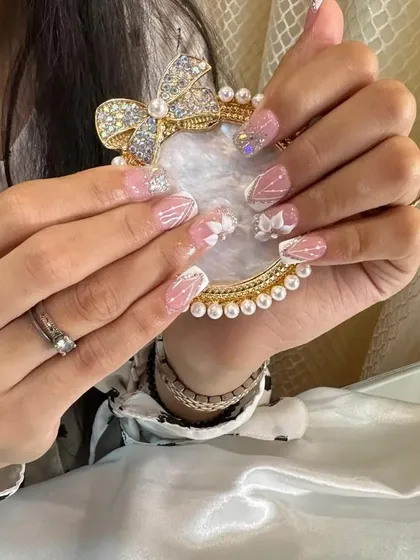 A beautiful and delicate set featuring a shimmery pink and white base, glitter, and intricate 3D flowers.