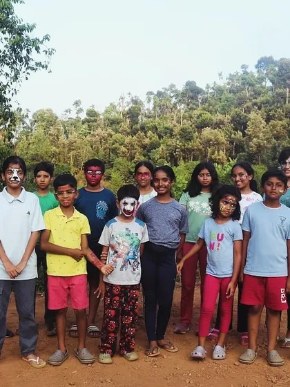 A group of campers with various face paint designs, ready for a fun camp activity.