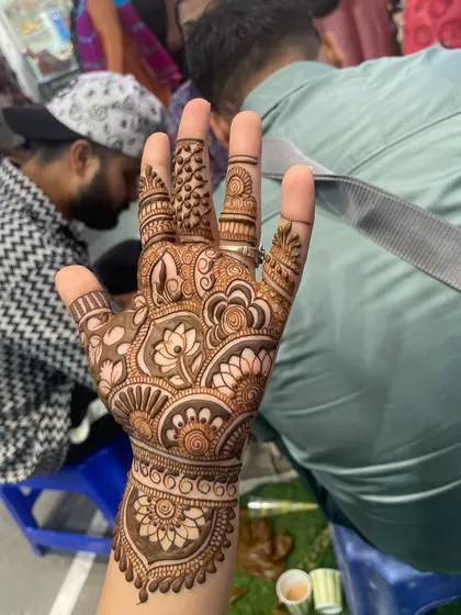 A single hand showing a beautiful floral design. This is a great example of a party mehandi that is detailed but not too heavy.