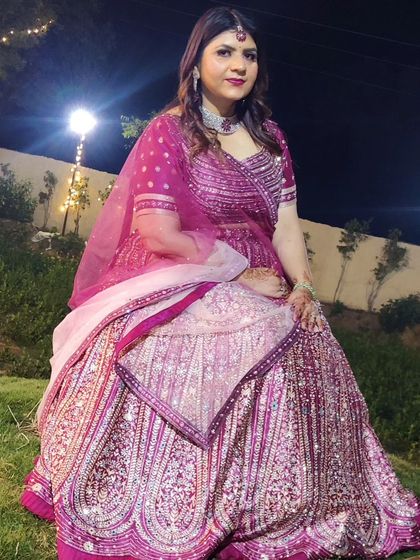 Here I am in one of my own creations. This heavily embroidered pink and purple lehenga shows the kind of rich, detailed work I love to design for my brides.
