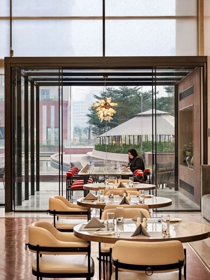 A glass-encased private dining area at the Elevate Clubhouse offers an exclusive experience while overlooking the outdoor landscape. This feature provides privacy without sacrificing the feeling of openness.